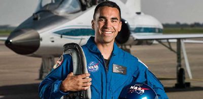 Kijk hoe NASA-astronaut Raja Chari met een robotarm naar een werkstation wordt vervoerd tijdens een ruimtewandeling buiten het internationale ruimtestation.
