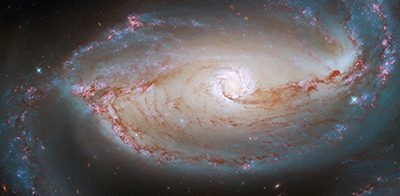 НАСА поделилось захватывающим снимком, сделанным его телескопом Хаббл галактики NGC 1097, расположенной в 48 миллионах световых лет от Земли. «Это изображение #HubbleFriday показывает не только сердце этой спиральной галактики с перемычкой, но и запутанную паутину звезд и пыли в ее центре», — говорится в сообщении.