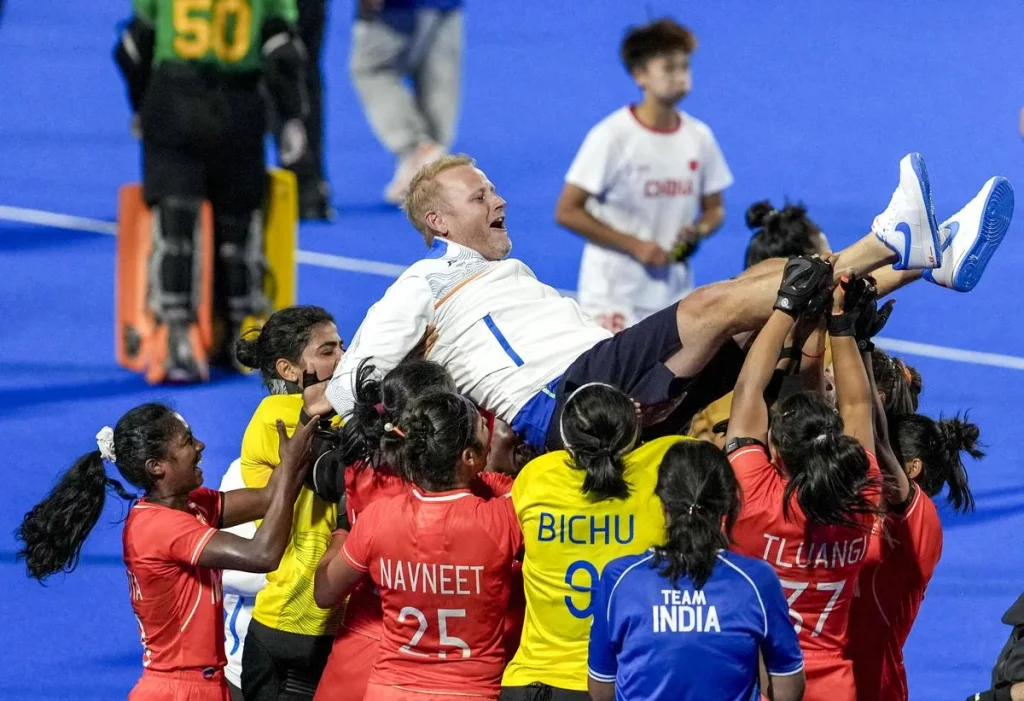 India’s players lift coach Sjoerd Marijne after winning the women’s gold medal match against China at the Asian Games._Photo by PTI